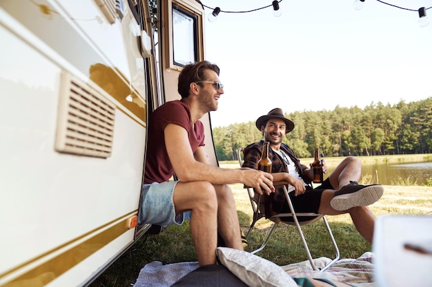 Foto amici sorridenti seduti accanto al furgone