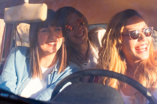 Photo smiling friends sitting in car