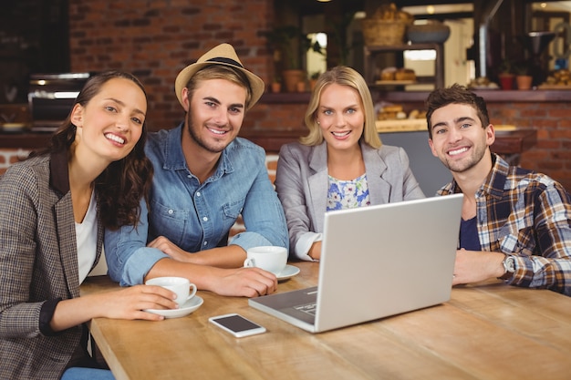 Smiling friends sitting and drinking coffee