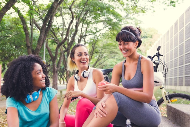 Smiling friends sitting in park