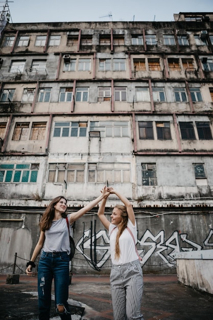 Smiling friends standing against building in city
