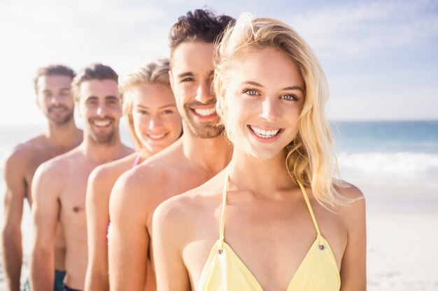 Smiling friends standing in line 