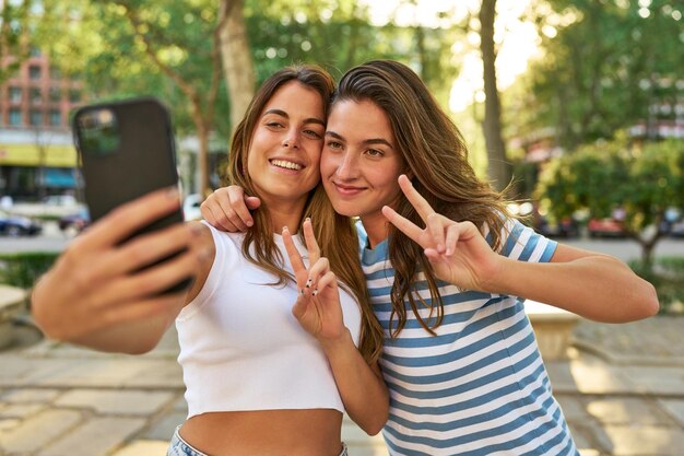 Photo smiling friends taking a selfie in the park