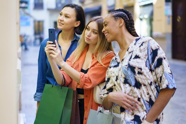 Foto amici sorridenti che usano il cellulare