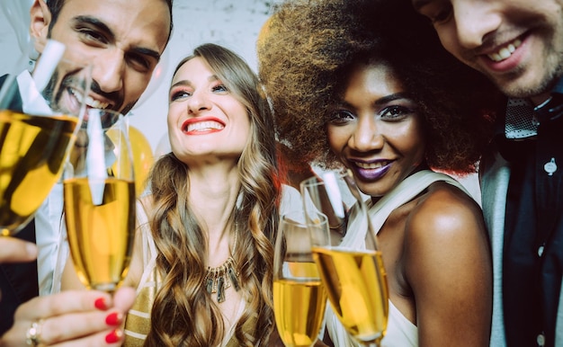 Photo smiling friends with champagne in party