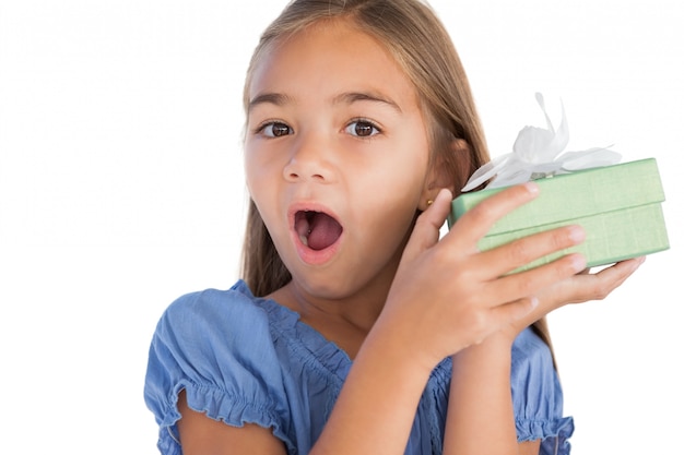 Smiling girl astonished while holding a present