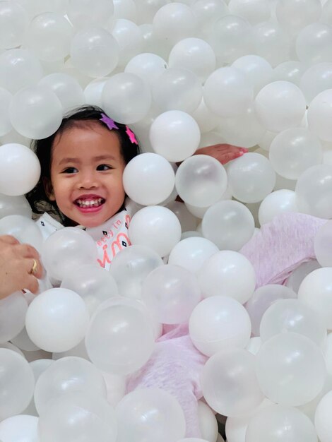 Photo smiling girl in ball pool