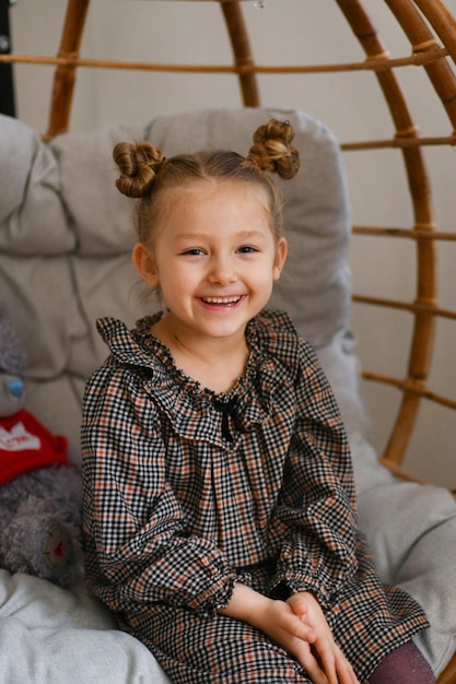 A smiling girl in a bamboo chair