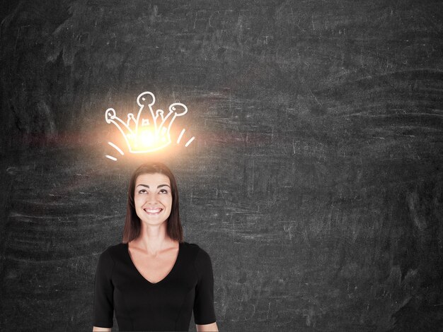 Foto ragazza sorridente in nero con corona