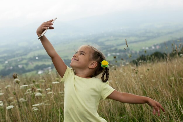 Photo smiling girl doing selfie on grassy field