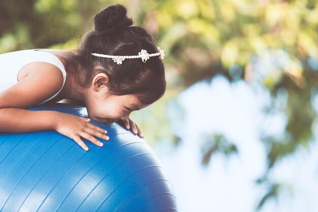 Photo smiling girl exercising on fitness ball