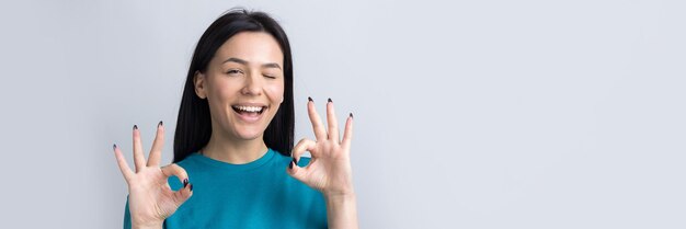 Ragazza sorridente che fa segno ok con la mano