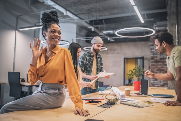 Smiling girl gesturing with hand at office