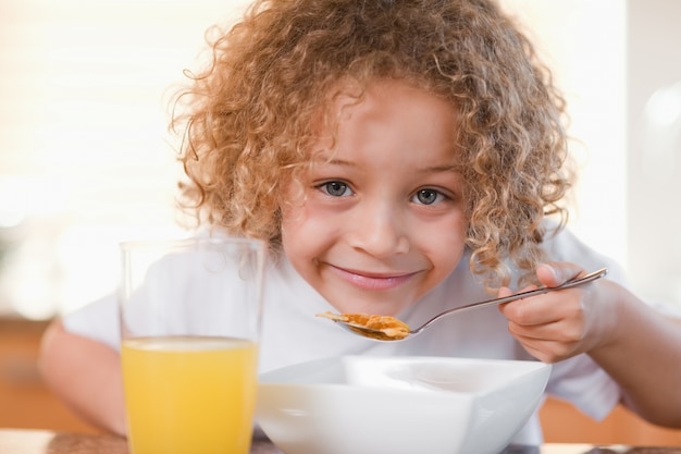 Photo smiling girl having breakfast