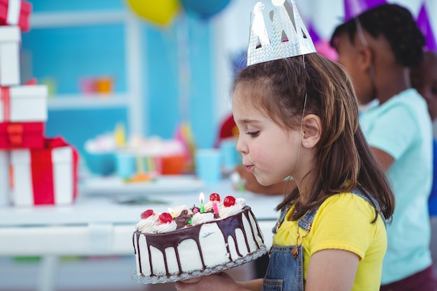 Smiling girl holding birthday cake