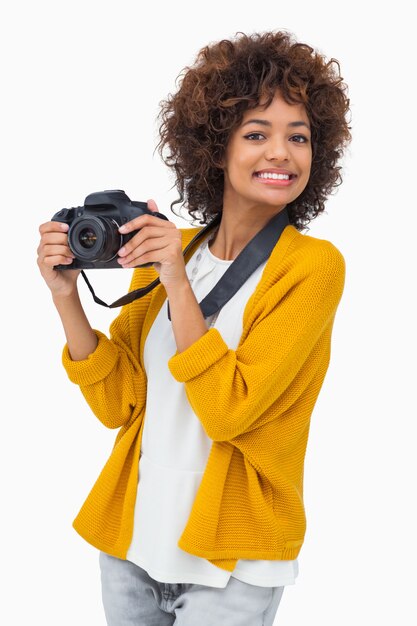 Smiling girl holding digital camera