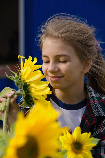 Smiling girl holding yellow flower outdoors