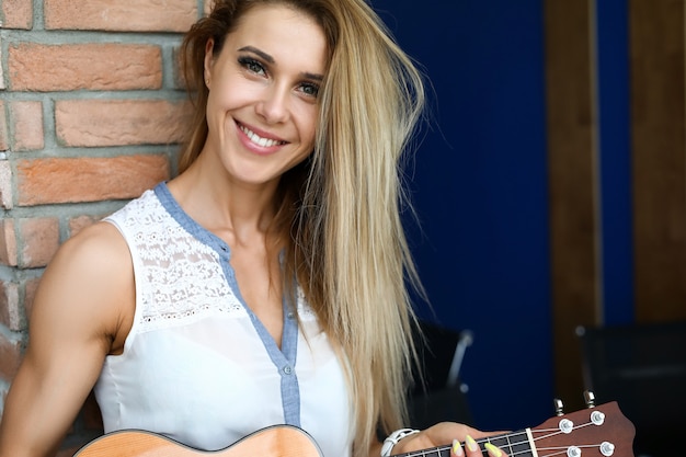 Photo smiling girl holds a ukulele