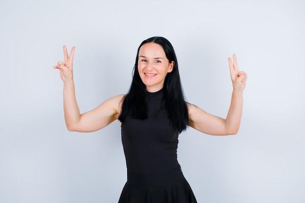 Smiling girl is showing two gestures on white background