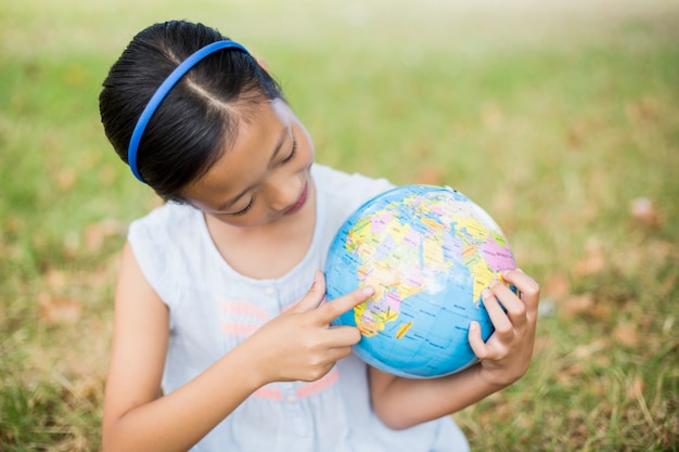 Smiling girl looking at globe