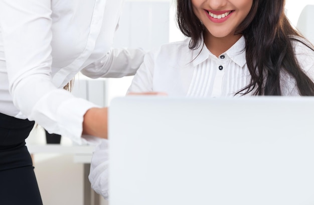 Foto ragazza sorridente che esamina lo schermo del computer portatile