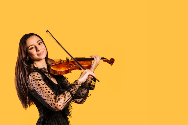 Foto ragazza sorridente che suona il violino