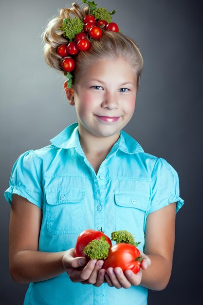 Photo smiling girl posing with wreath of cherry tomatoes