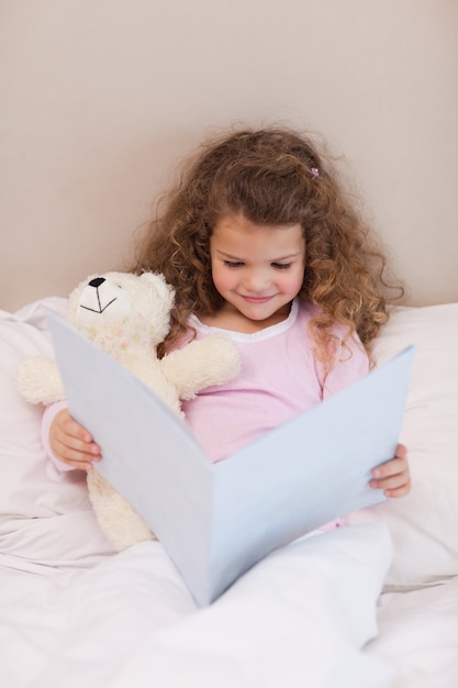 Photo smiling girl reading a book