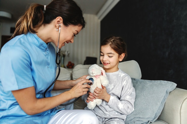Photo smiling girl sitting on sofa and holding her bunny toy. doctor trying to relax girl so she is pretending to examining her bunny with stethoscope.