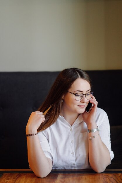 Ragazza sorridente di trascorrere del tempo in un caffè di strada utilizzando gadget digitali