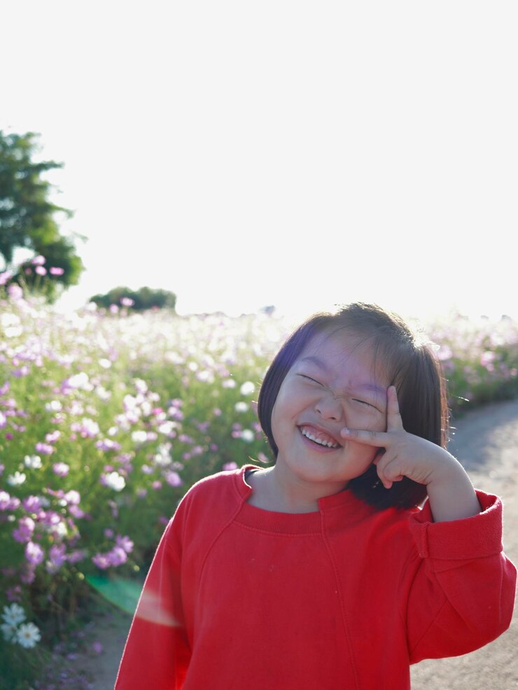 Photo 明るい空に照らされた植物の中に立っている微笑む女の子