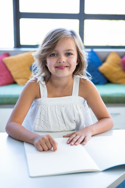 Smiling girl studying in school library