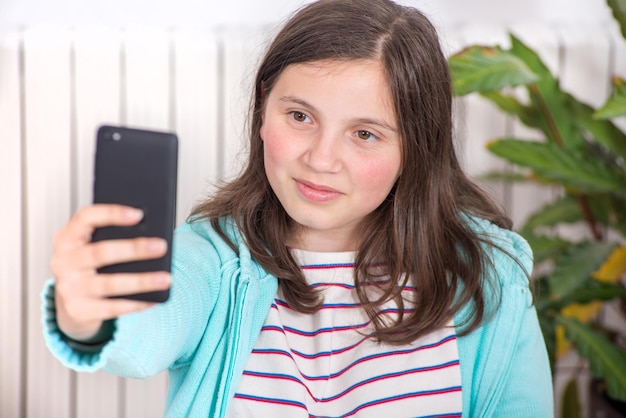 Photo smiling girl taking selfie over smart phone