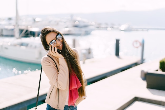 Smiling girl talking on the phone on the pier