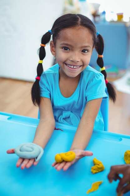 Smiling girl using modelling clay