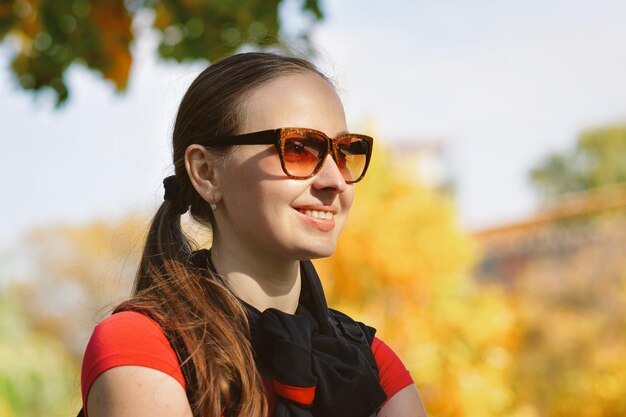 Smiling girl wearing sunglasses at Novodevichy Convent Park in Moscow in Russia