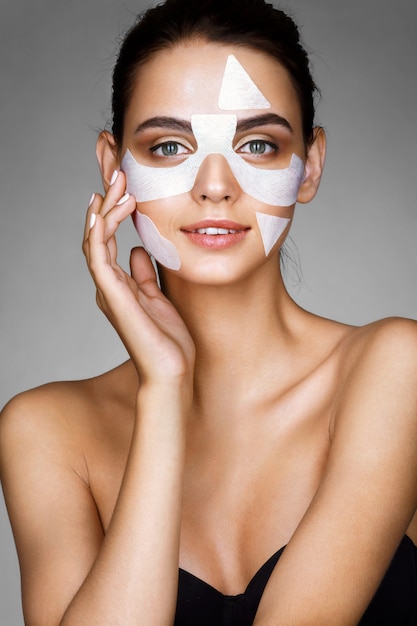 Ragazza sorridente con maschera facciale in cotone