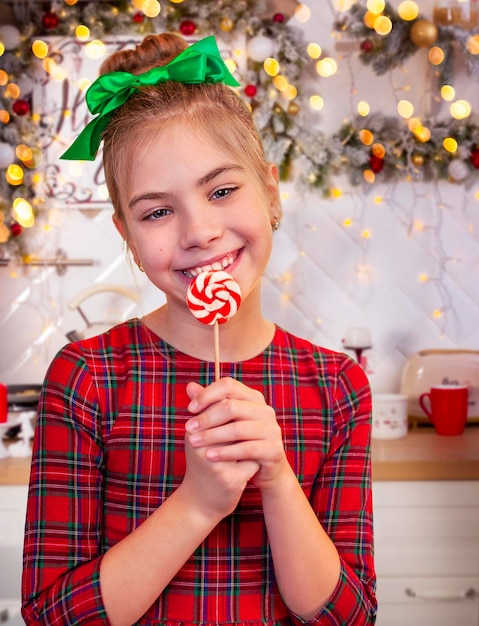 smiling girl with a lollipop in her hands in the kitchen