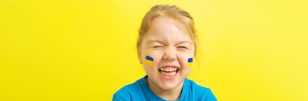 Smiling girl with a painted ukrainian flag of yellow and blue on her cheeks