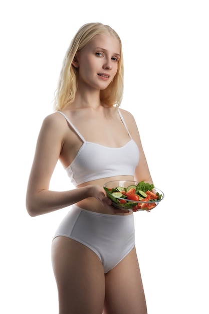 Smiling girl with a salad on a white background.