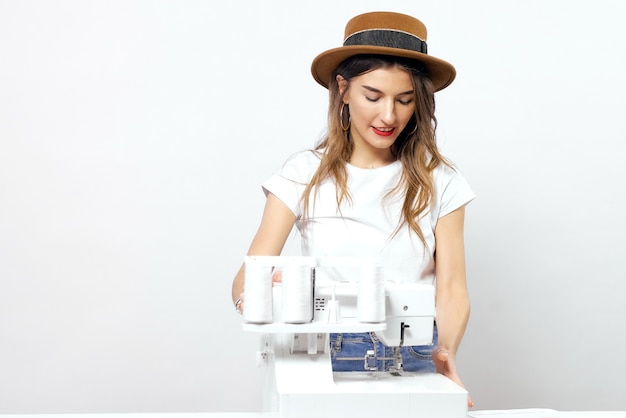Photo smiling girl with sewing machine poses for photo high quality photo