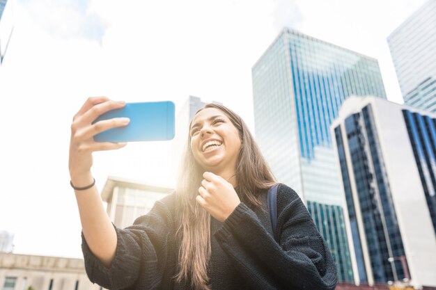 Smiling girl with smart phone in Chicago