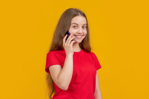 Smiling girl with smartphone on yellow background