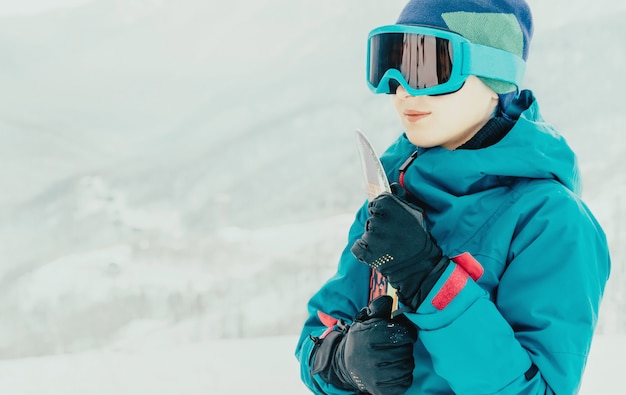 Smiling girl with snowboard in winter