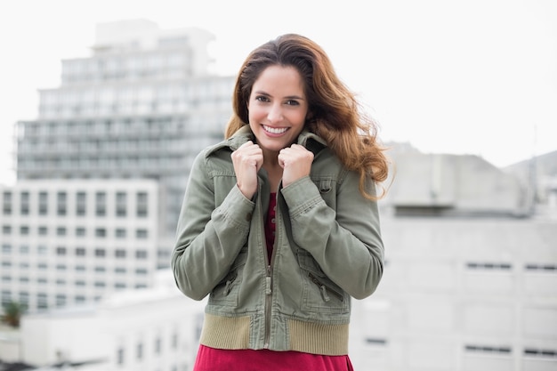 Smiling gorgeous brunette in winter fashion grabbing collar