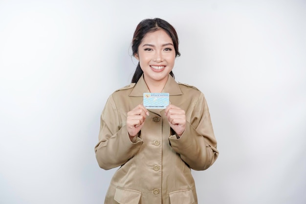 Foto una donna sorridente che lavora per il governo con una carta d'identità indonesiana pns che indossa un'uniforme khaki