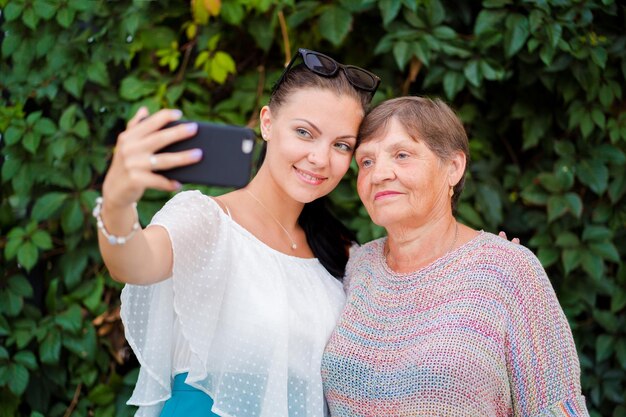 Photo smiling granddaughter taking selfie with grandmother