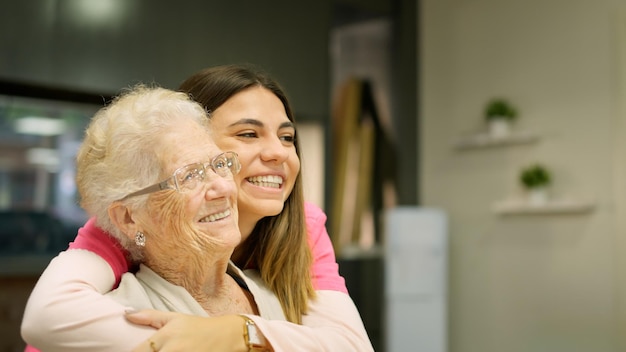 Smiling grandmother and granddaughter looking at copy space