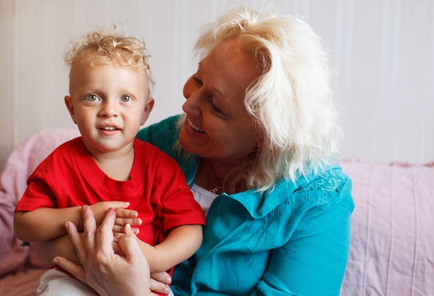 Photo smiling grandmother with grandson at home