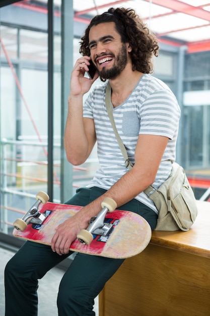 Smiling graphic designer talking on mobile phone